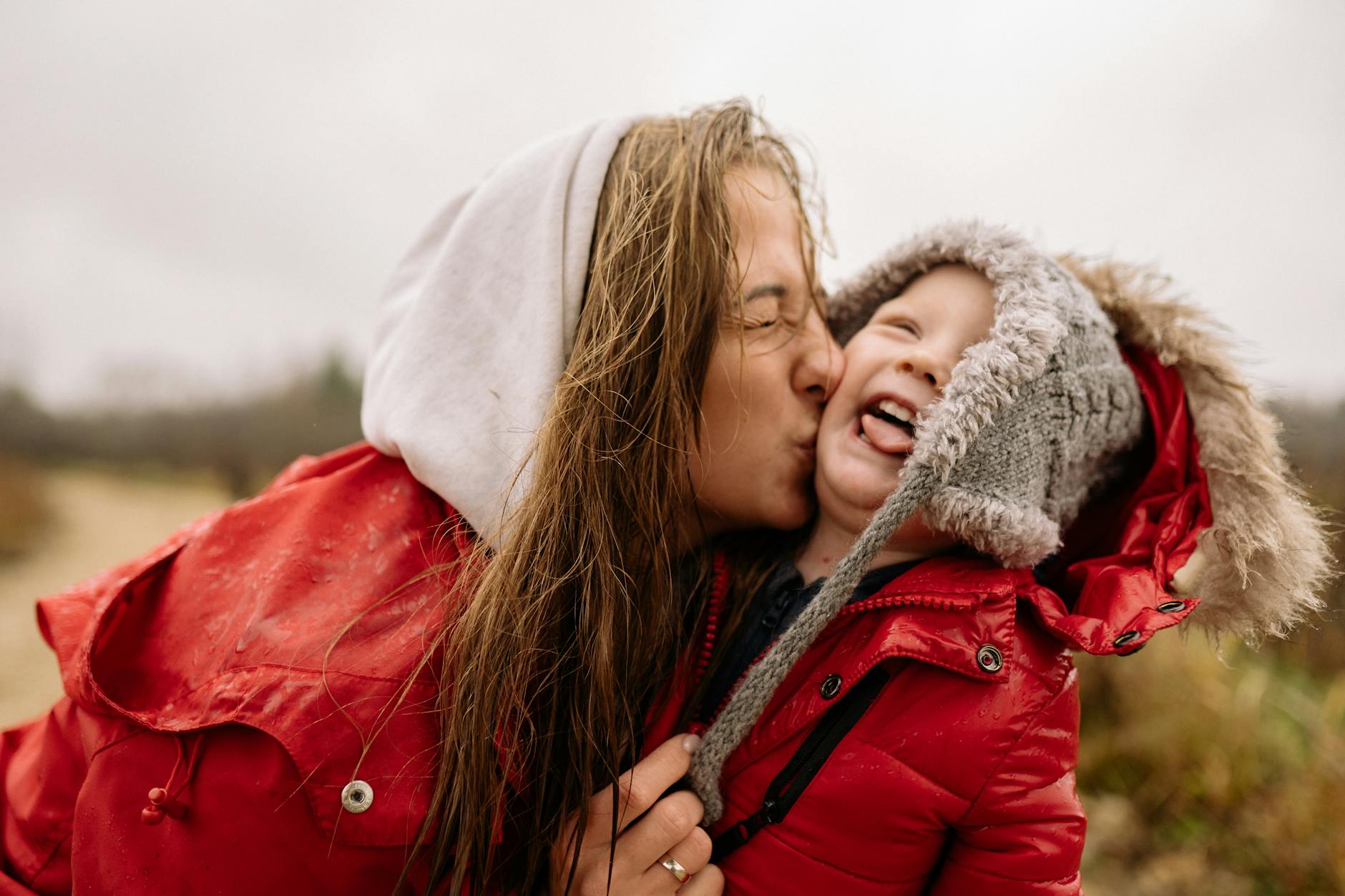 A waterproof red duck feather jacket with a hood, perfect for wet and rainy winter weather.